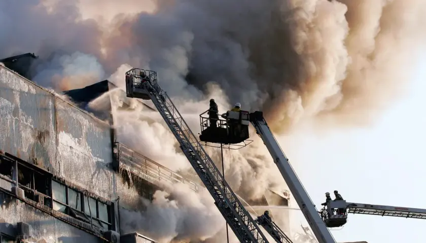 Vigili del fuoco da piattaforme aeree combattono un incendio in un edificio, dimostrando che la lana di roccia è ignifuga.