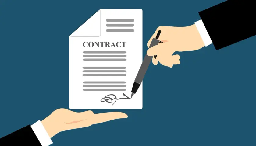 Manos firman un contrato de trabajo. Es obligatorio firmar un contrato de trabajo para formalizar el empleo.