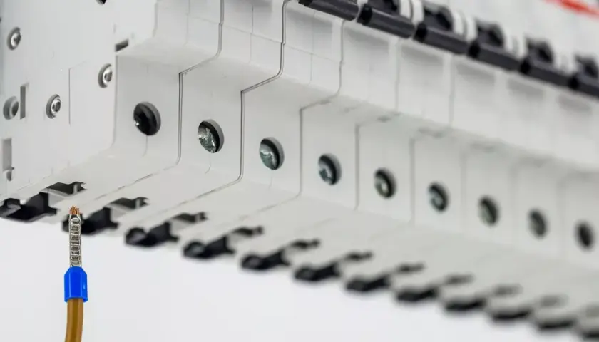 Szukasz informacji o uzbrojenie rozdzielni elektrycznej cena? Widok na bezpieczniki i przewód uziemiający.