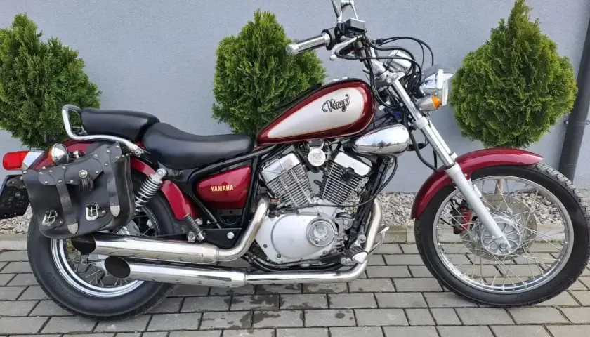 Klasyczny motocykl Yamaha Virago 125, z sakwami i ozdobnym malowaniem. Idealny do miasta, jego wymiary są kompaktowe.
