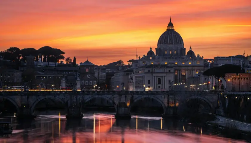 Tramonto infuocato su Roma, con San Pietro e Ponte Sant'Angelo. Un'immagine iconica della città eterna, perfetta per la alta stagione Roma.