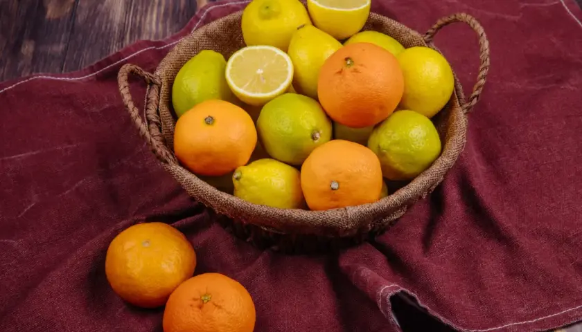 Koszyk pełen cytrusów: pomarańczy, cytryn i limonek. Te owoce są bogate w hesperydynę, cenny flawonoid.