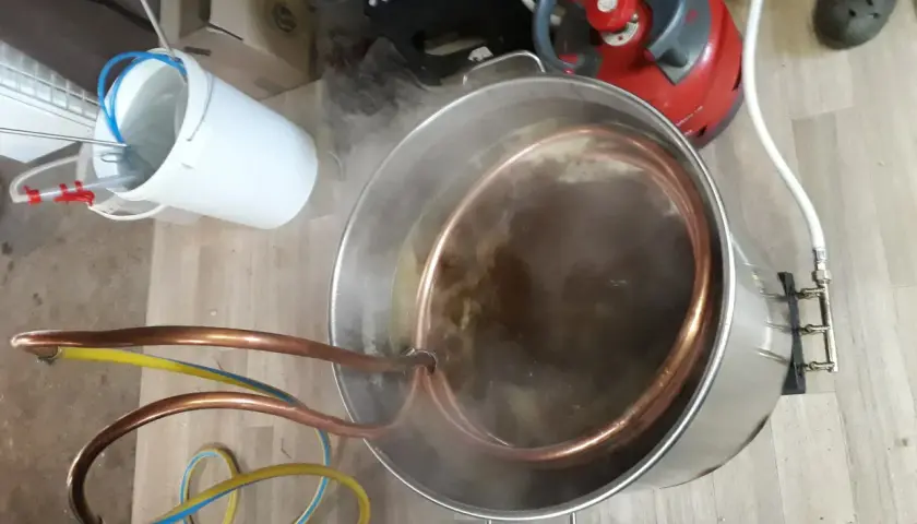 Préparation d'une bière artisanale avec un système de whirlpool. Le moût bouillonne dans la cuve en inox, traversé par un serpentin en cuivre.
