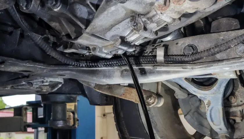 Podczas wymiany oleju w skrzyni manualnej, czarny pręt wchodzi do mechanizmu, by spuścić zużyty płyn.