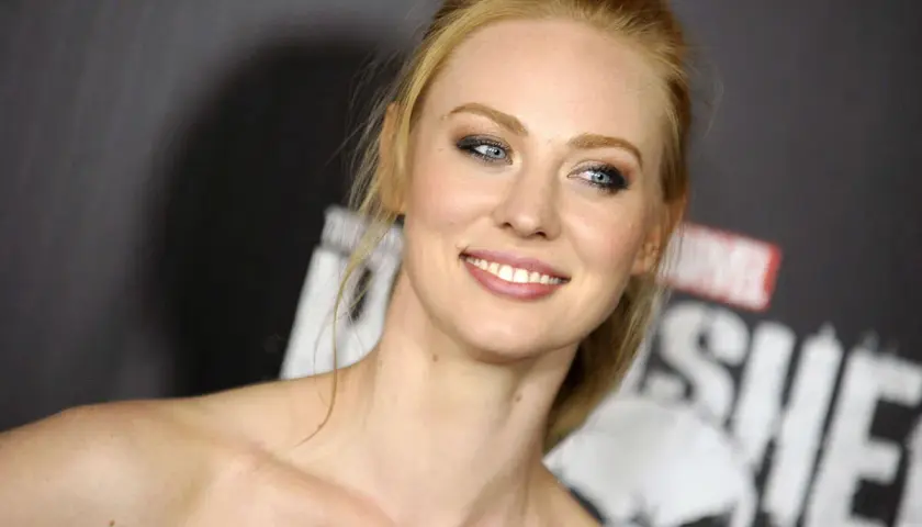 Deborah Ann Woll, qui a joué Karen Page, souriant devant le logo de The Punisher.