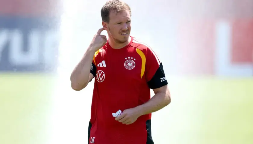 Trener reprezentacji Niemiec, Julian Nagelsmann, w czerwonej koszulce z godłem DFB, gestykuluje podczas treningu.