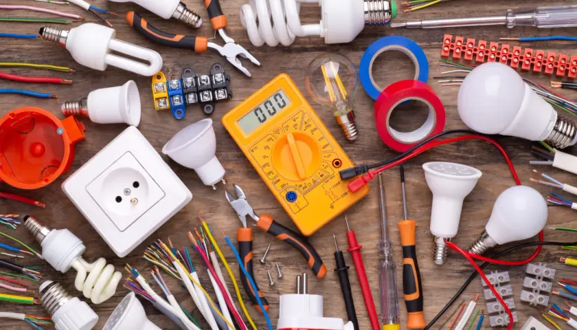 Wszystkie potrzebne materiały do instalacji elektrycznych: kable, żarówki, gniazdko, miernik, taśmy i narzędzia. Idealne dla hurtowni kabli i osprzętu elektroinstalacyjnego.