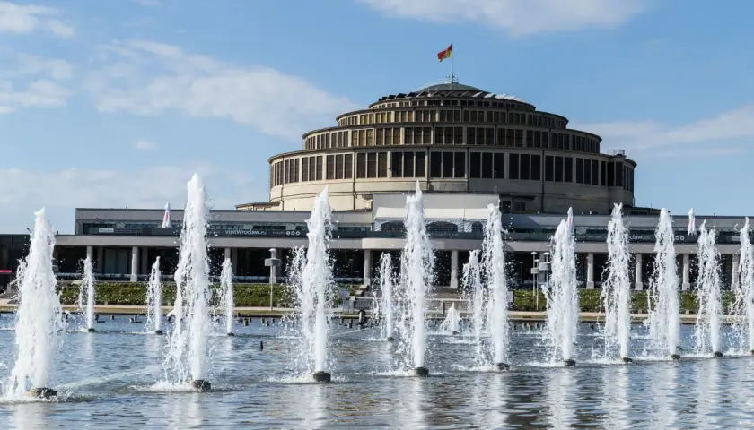 Wrocławska Hala Stulecia, jeden z obiektów UNESCO w Polsce, z fontannami w letni dzień.
