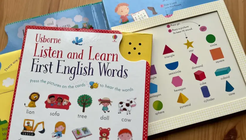 Książka "Listen and Learn First English Words" zachęca do nauki słówek po angielsku. Na kartach są obrazki zwierząt, przedmiotów i kształtów.