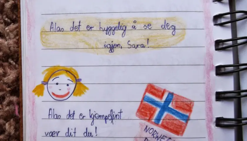 Złote myśli do pamiętnika dla dzieci: rysunek dziewczynki i flagi Norwegii. "Norwegia rządzi!" - pisze mały podróżnik.