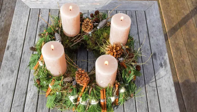 Natürlicher Adventskranz mit vier Kerzen, Tannenzweigen, Zapfen und Zimtstangen. Tolle Adventskranz Ideen für ein gemütliches Zuhause.
