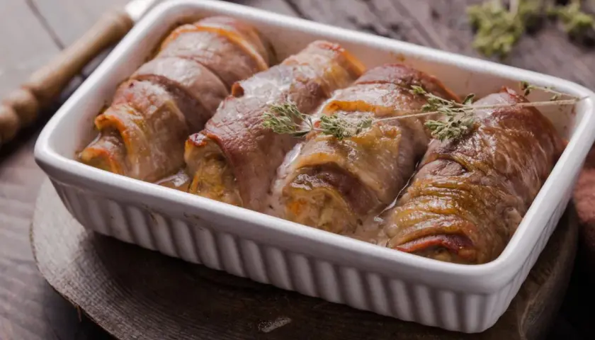 Roladki schabowe w sosie, zawinięte w boczek, wyglądają soczyście. Kluczem do sukcesu jest odpowiednie przygotowanie, by nie były suche.