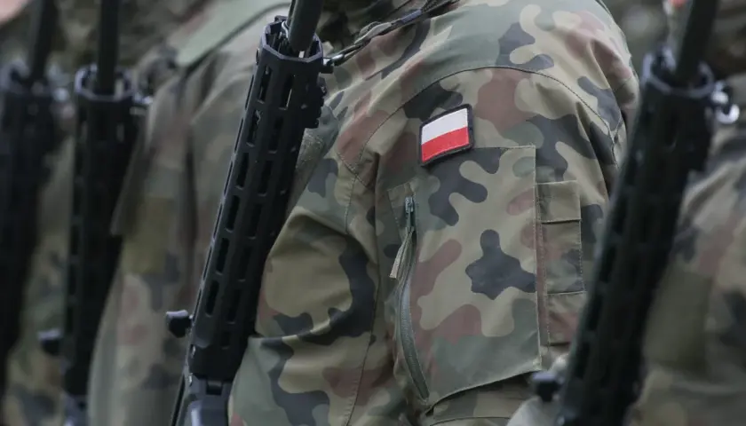Żołnierze w kamuflażu, z karabinami, gotowi do akcji. Widoczna polska flaga na rękawie. To symbol 4 gwiazdek w wojsku.