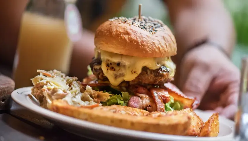 Ogromny burger z rozpływającym się serem, chrupiącym boczkiem i surówką. Wygląda jak posiłek dla prawdziwego drwala!