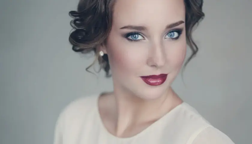 Maquillaje para vestido blanco: ojos ahumados, labios rojos y peinado recogido.