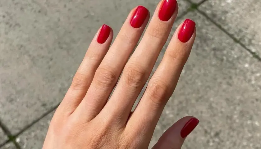 Manos con uñas rojas decoradas elegantes, un toque de glamour para cualquier ocasión.
