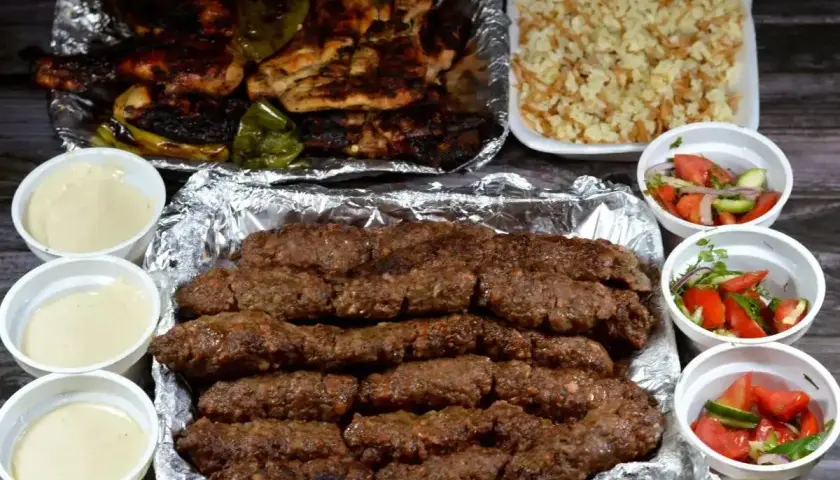 Pyszny kofta kebab z grillowanym kurczakiem, ryżem i sałatkami. Idealny posiłek na wynos.