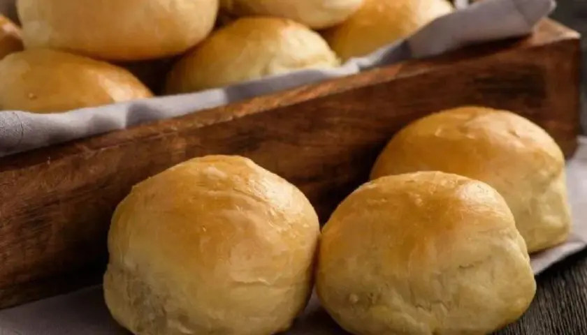 Pan de cebolla recién horneado, dorado y esponjoso, servido en una cesta de madera.