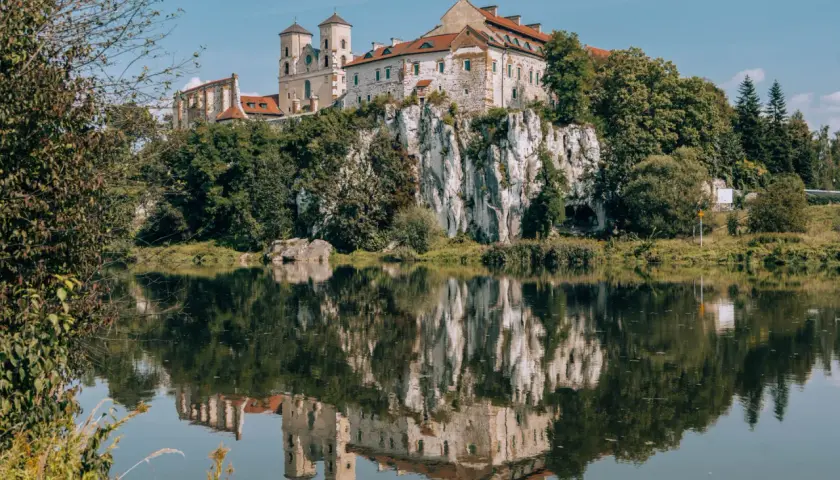 Zamek w Tyńcu na skale, odbijający się w spokojnej wodzie.
