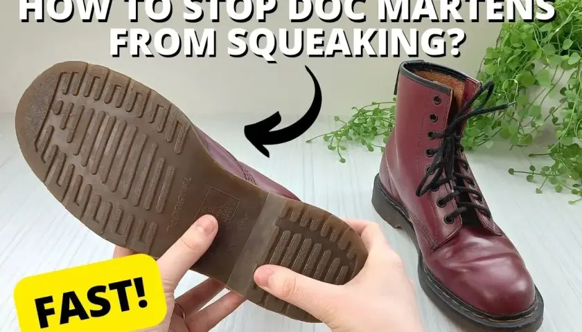 Hands hold a burgundy Doc Marten boot, showing its sole. A second boot sits nearby. Learn why are my boots squeaking when I walk and how to fix it FAST!