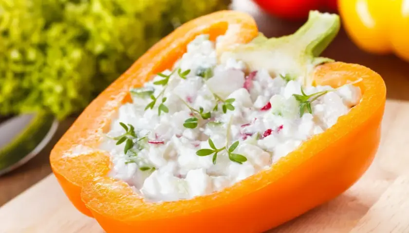 Pomarańczowa papryka faszerowana twarożkiem i ziołami. Papryka właściwości odżywcze czynią ją idealną bazą dla zdrowych przekąsek.