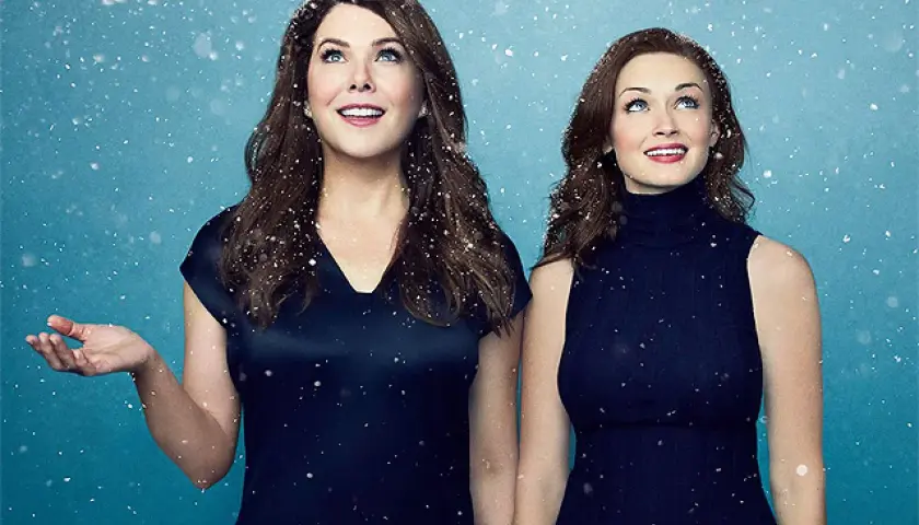 Kochane kłopoty rok z życia obsada: Lauren Graham i Alexis Bledel w zimowej scenerii, patrzą w górę z uśmiechem.