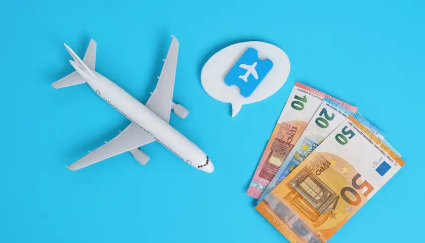 Avión de juguete, billetes de euro y un ticket aéreo. Piensa en cuándo es mejor comprar vuelos para ahorrar.
