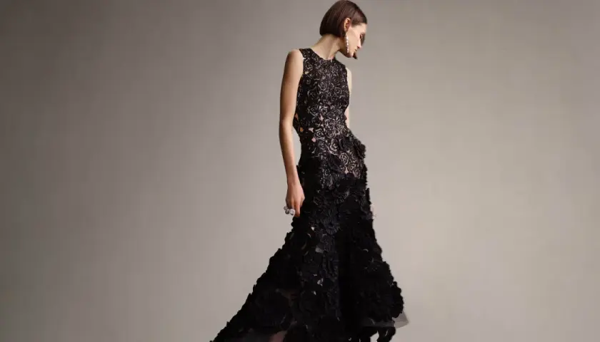 Modelka w czarnej, koronkowej sukni z falbanami, idealnej na black tie dress code damski.