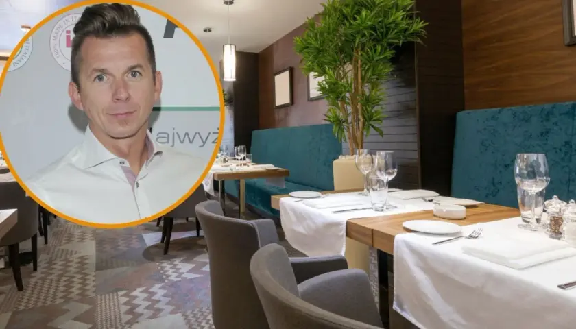 Karol Okrasa w eleganckiej restauracji, gotowy na degustację wykwintnych dań.