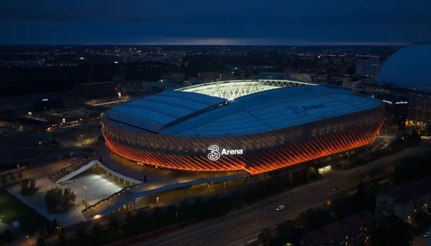 Tele2 Arena i Stockholm lyser upp natthimlen med sitt orangea sken. En ikonisk plats för evenemang.