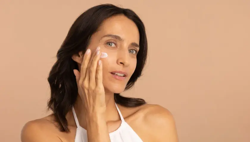 Une femme applique une crème hydratante pour lutter contre la peau sèche.