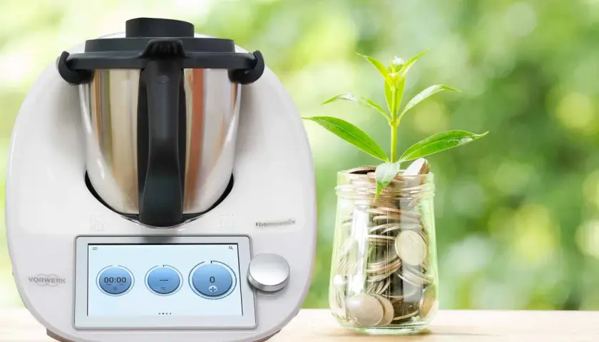 Thermomix i słoik z monetami, symbolizujące oszczędność energii. Dowiedz się, ile prądu pobiera Thermomix, by gotować ekonomicznie.