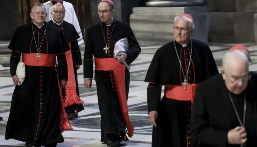 Kardynałowie w czarnych szatach z czerwonymi pasami idą w procesji. To ważny moment, zbliża się wybór papieża.