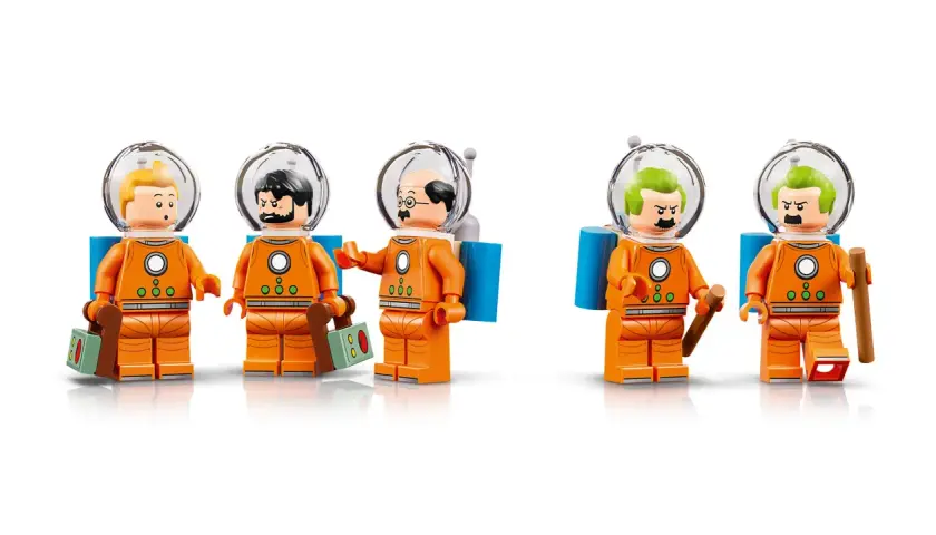 Fünf Lego-Figuren in orangefarbenen Raumanzügen mit Helmen. Sie erinnern an Tim und Struppi auf dem Mond.