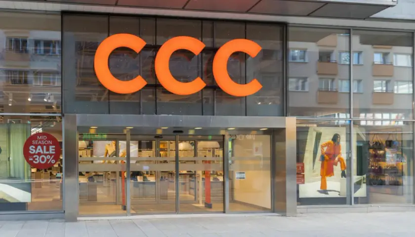 Elegancka fasada sklepu CCC z pomarańczowym logo i witryną z promocją -50%.