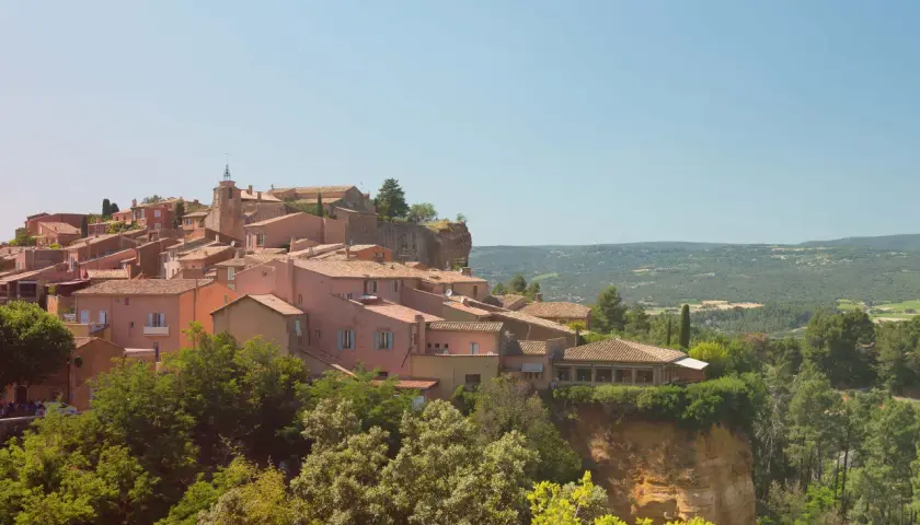 Village de Roussillon, terre du midi rosé, avec ses maisons ocres perchées sur une falaise. Un paysage provençal qui invite à la dégustation.