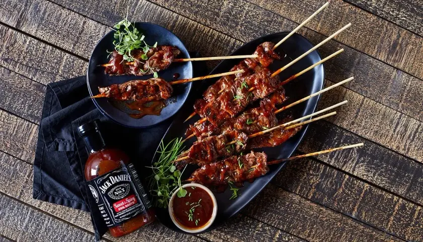 Brochettes de bœuf glacées à la marinade Jack Daniel's, servies avec une sauce barbecue.