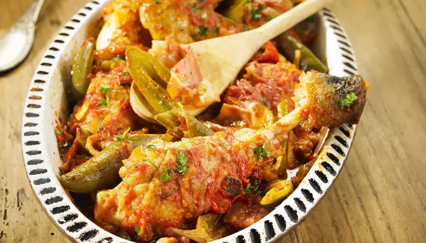 Un plat de poulet basquaise appétissant, préparé au Cookeo, garni de poivrons verts et d'une sauce tomate savoureuse.