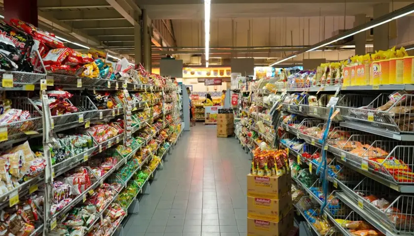 Długie alejki pełne kolorowych opakowań, typowe dla **Holandii sklepy** spożywcze. Widać mnóstwo przekąsek, słodyczy i produktów instant.