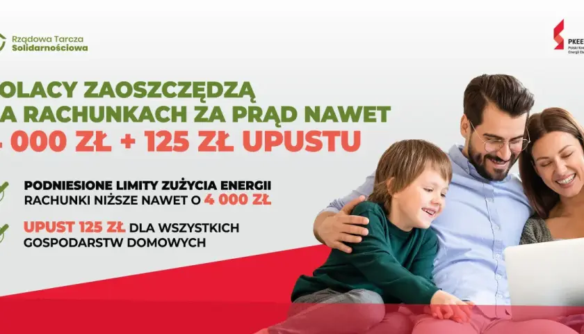 Uśmiechnięta rodzina z dzieckiem patrzy na laptopa, obok tekst o oszczędnościach na prądzie.