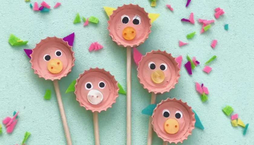 Fünf süße Schweinchen-Gesichter, gebastelt mit Kronkorken, Augen und Knöpfen. Eine tolle Idee zum Basteln mit Kronkorken!