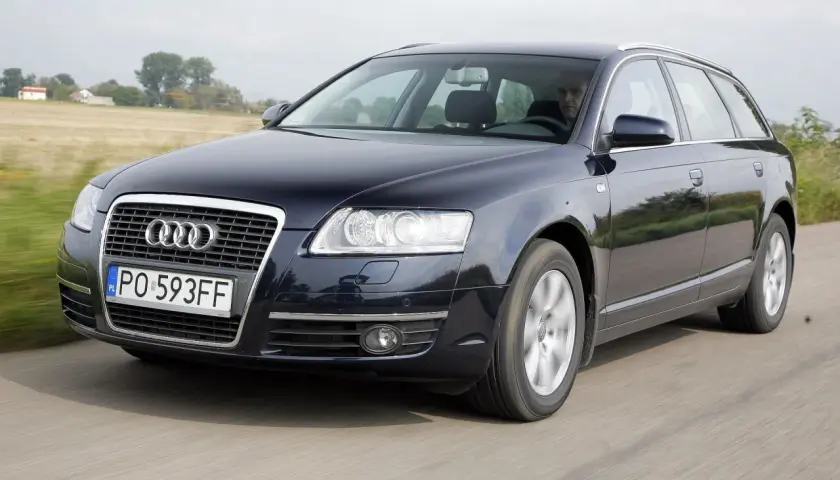 Ciemnogranatowe Audi A6 C6 2.7 TDI Avant w ruchu, z widocznym kierowcą i polskimi tablicami rejestracyjnymi.