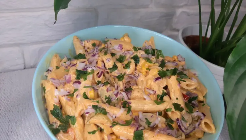 Pyszna sałatka gyros z makaronem penne, kukurydzą, czerwoną cebulą i natką pietruszki w kremowym sosie.