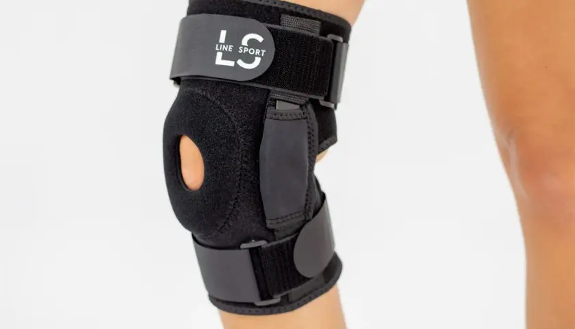 Czarny stabilizator kolana z logo "LS LINE SPORT" zapewnia wsparcie i stabilizację.