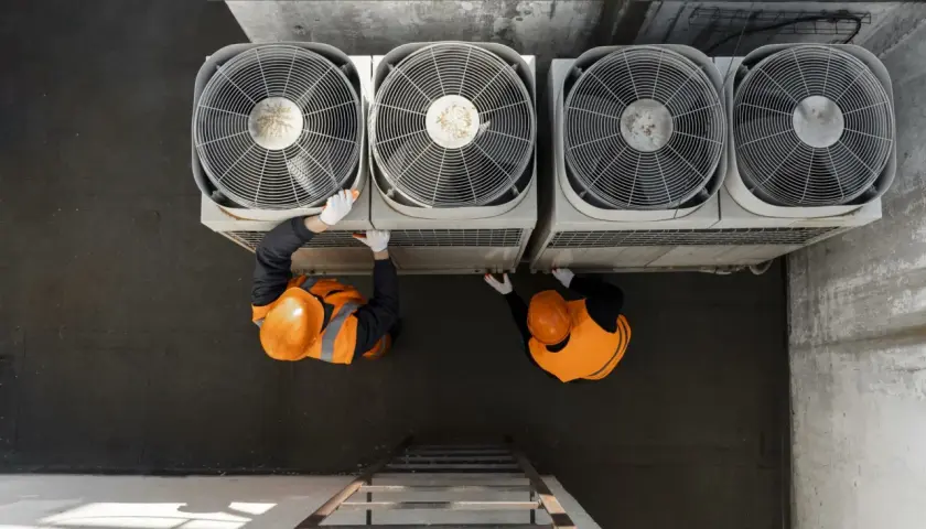Dos técnicos revisan unidades de aerotermia que es un sistema eficiente de climatización.