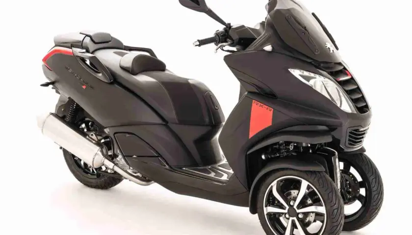 Scooter tres ruedas 2015, negro mate con detalles rojos, diseño deportivo y moderno.