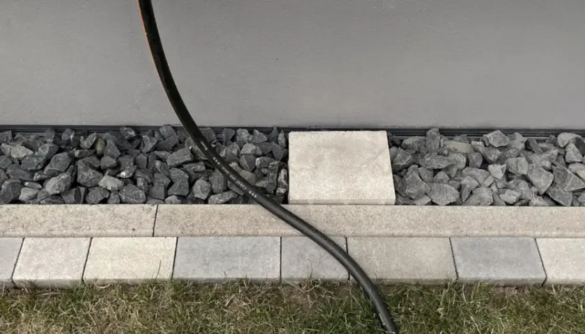 Moderner Spritzschutz am Haus: Kies und Steinplatten schützen die Fassade vor Nässe.