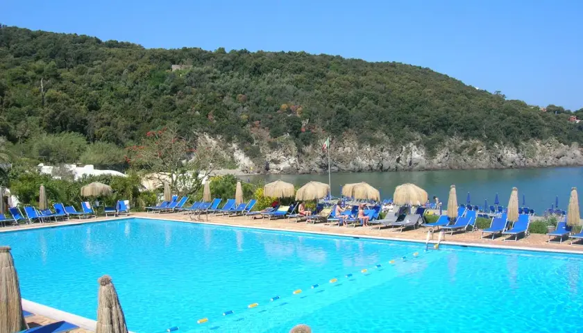 Piscina con lettini e ombrelloni, vista mare e collina verde. Informazioni su Negombo prezzi e orari per una vacanza rilassante.