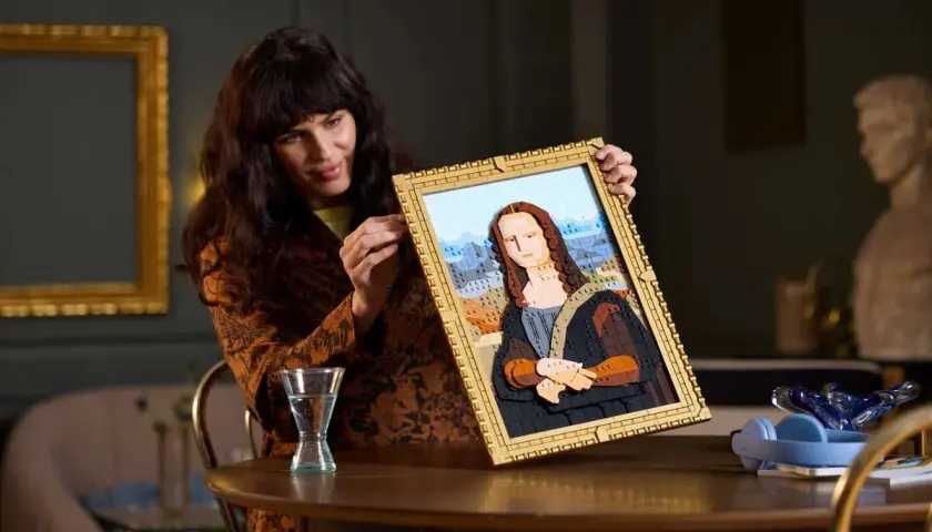 Frau hält ein detailreiches Lego-Mona-Lisa-Bild hoch.