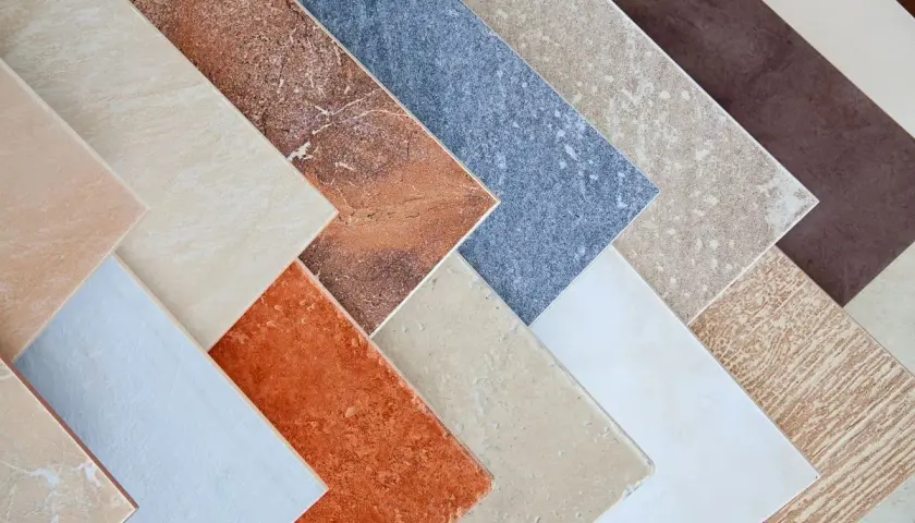 Campione di pavimenti sottili da sovrapporre in varie tonalità e texture, dal beige al marrone, dall'arancione al blu.